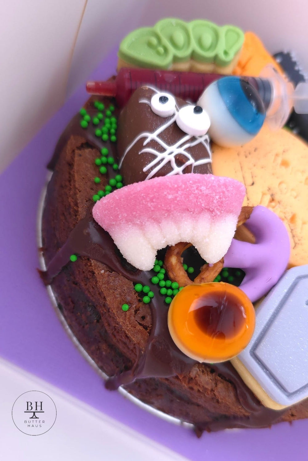 Close up of Halloween brownie with BOO cookie, pumpkin cookie, gummy eyeballs and sour gummy fangs