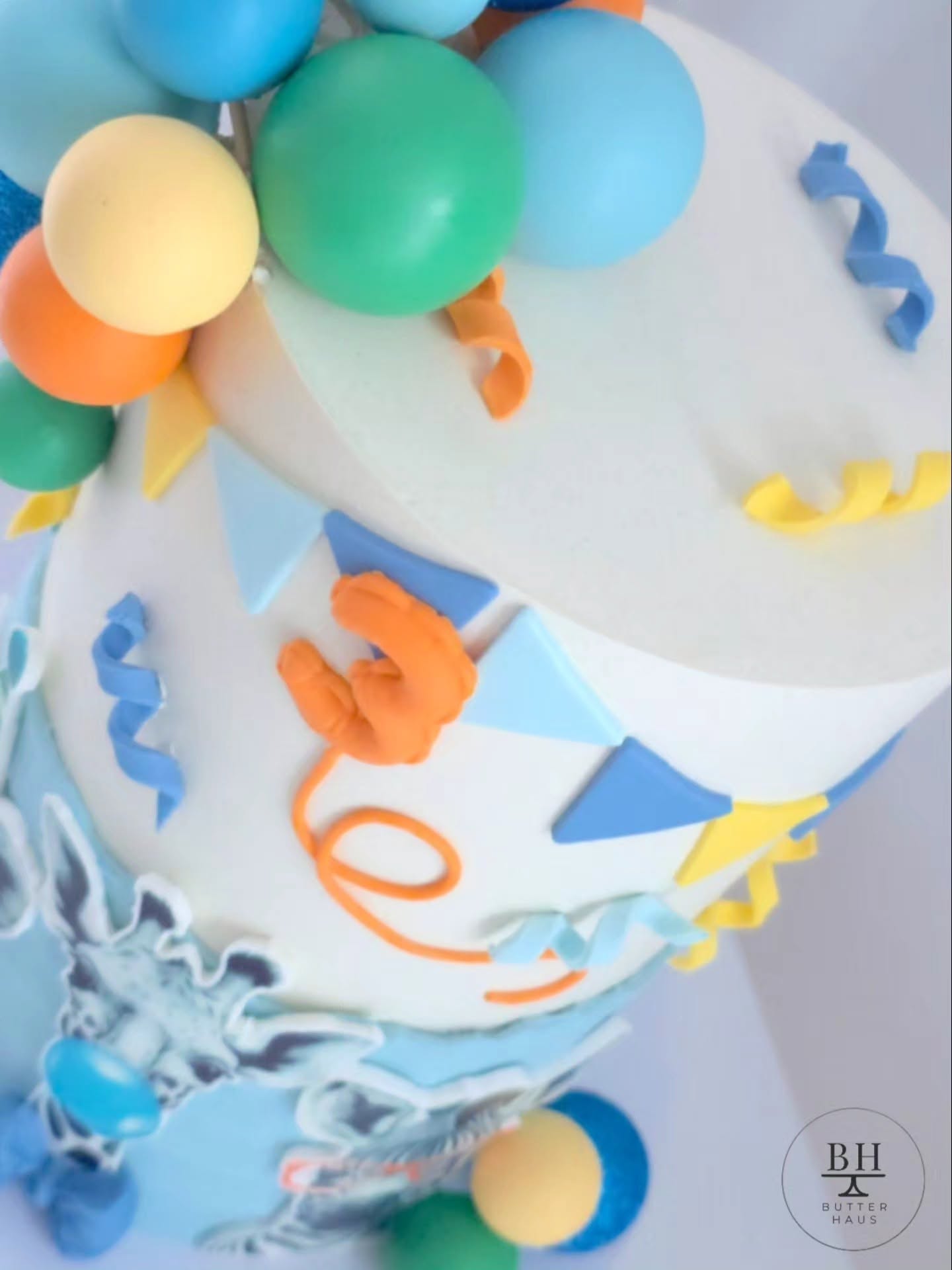 Close-up of party-hat-wearing lion cub and bubblegum-blowing giraffe cutouts on Party Animals cake