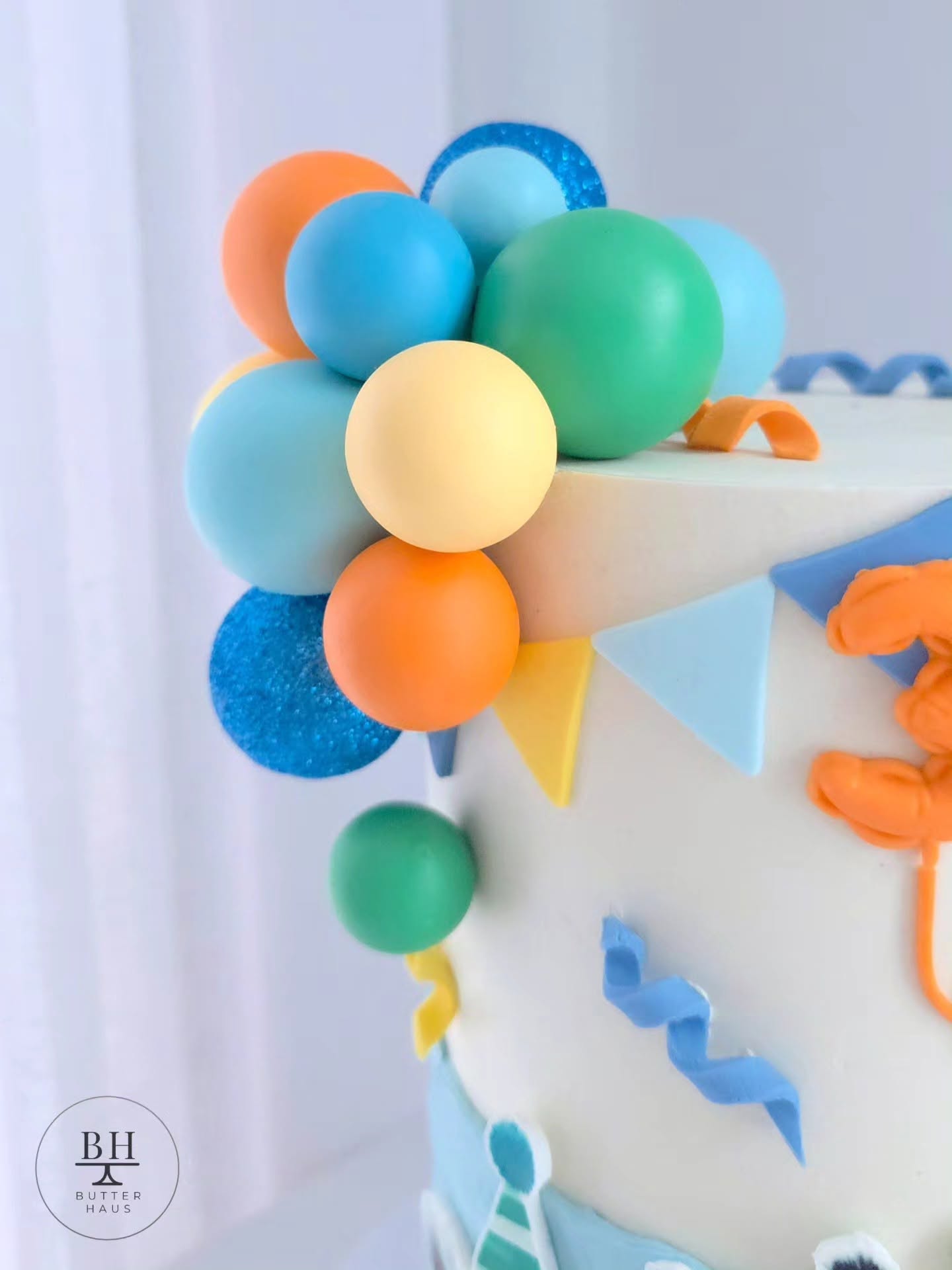 Side view of Party Animals cake with fondant bunting flags