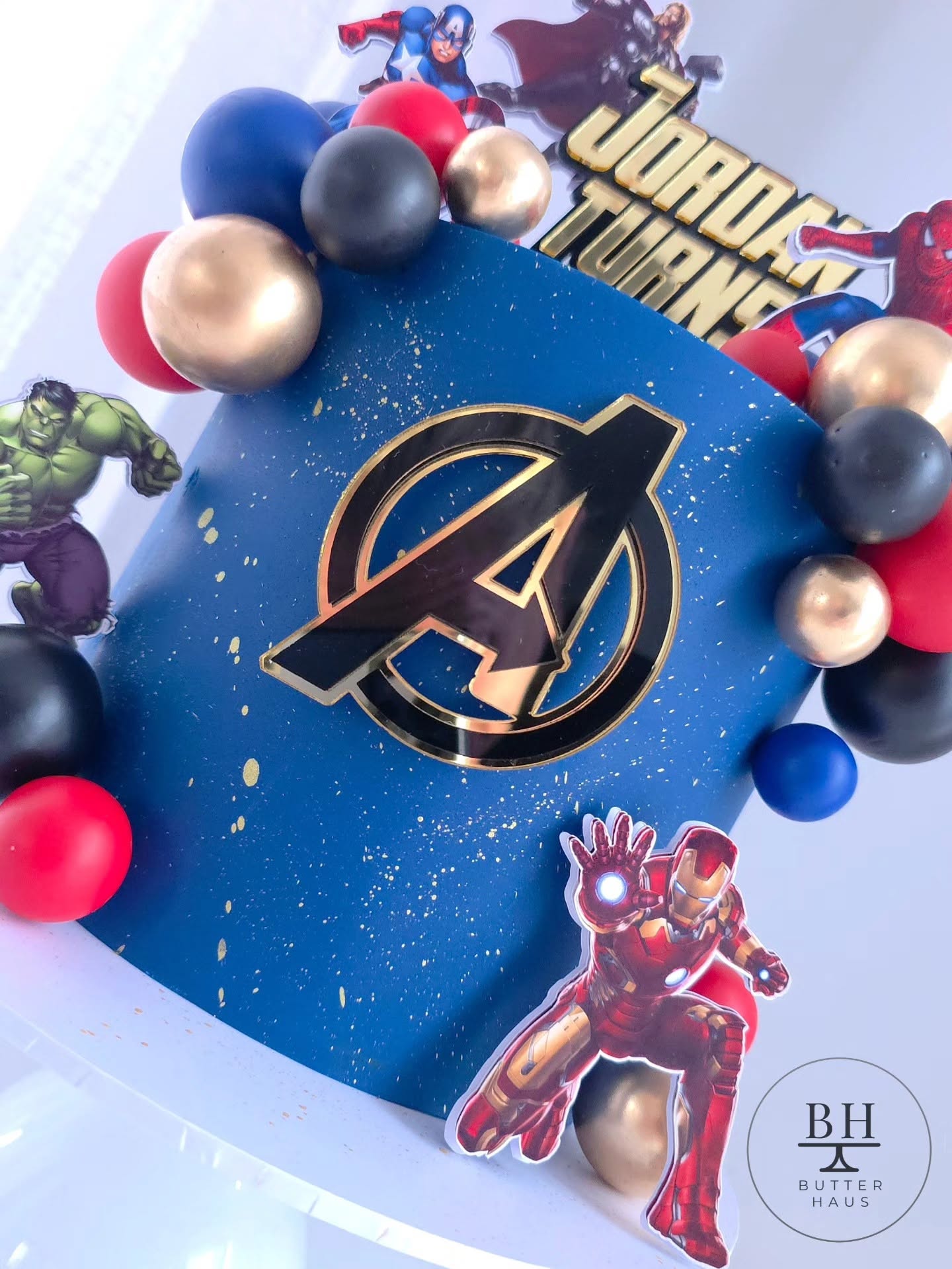 Avengers birthday cake with custom gold Name Turns Age topper, featuring Thor, Captain America and Spider-Man cardstock cutouts
