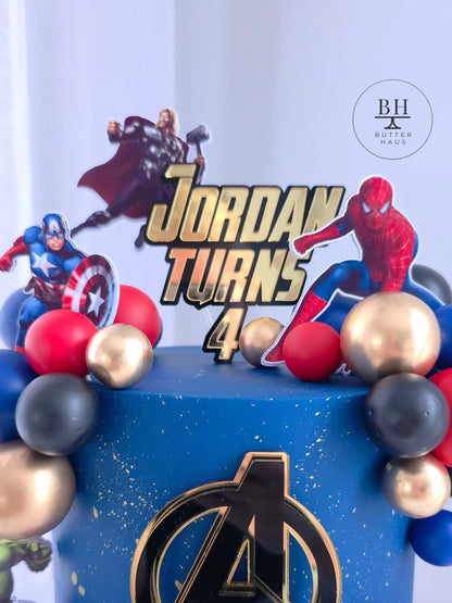 Avengers birthday cake with Hulk and Iron Man cardstock cutouts on gold-speckled galaxy-effect buttercream