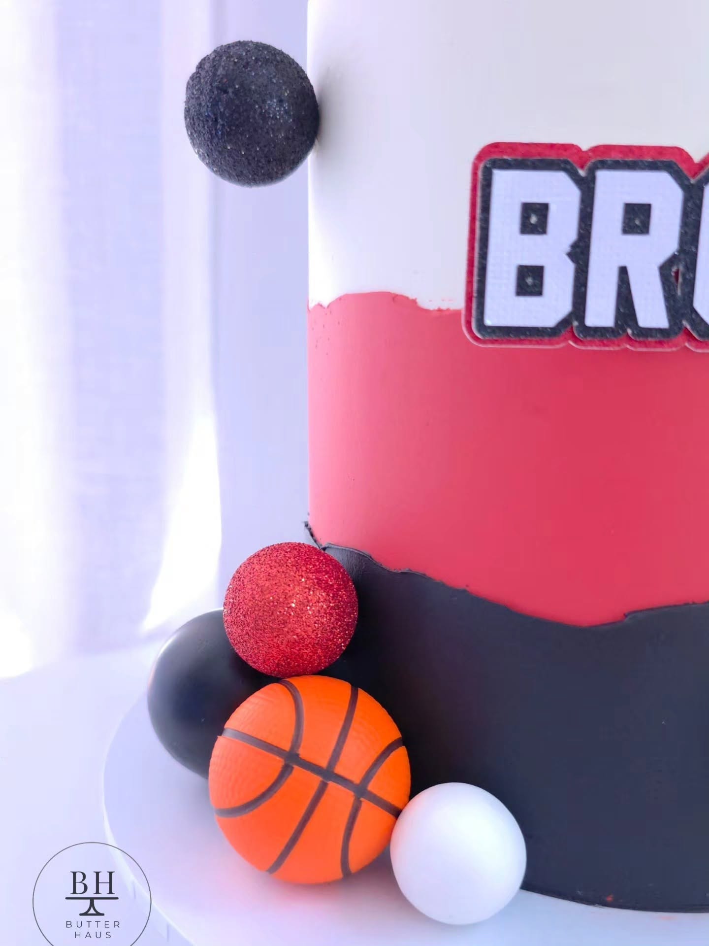 Close-up of the jump-shot silhouette topper and scoreboard-style hoop topper on the basketball birthday cake