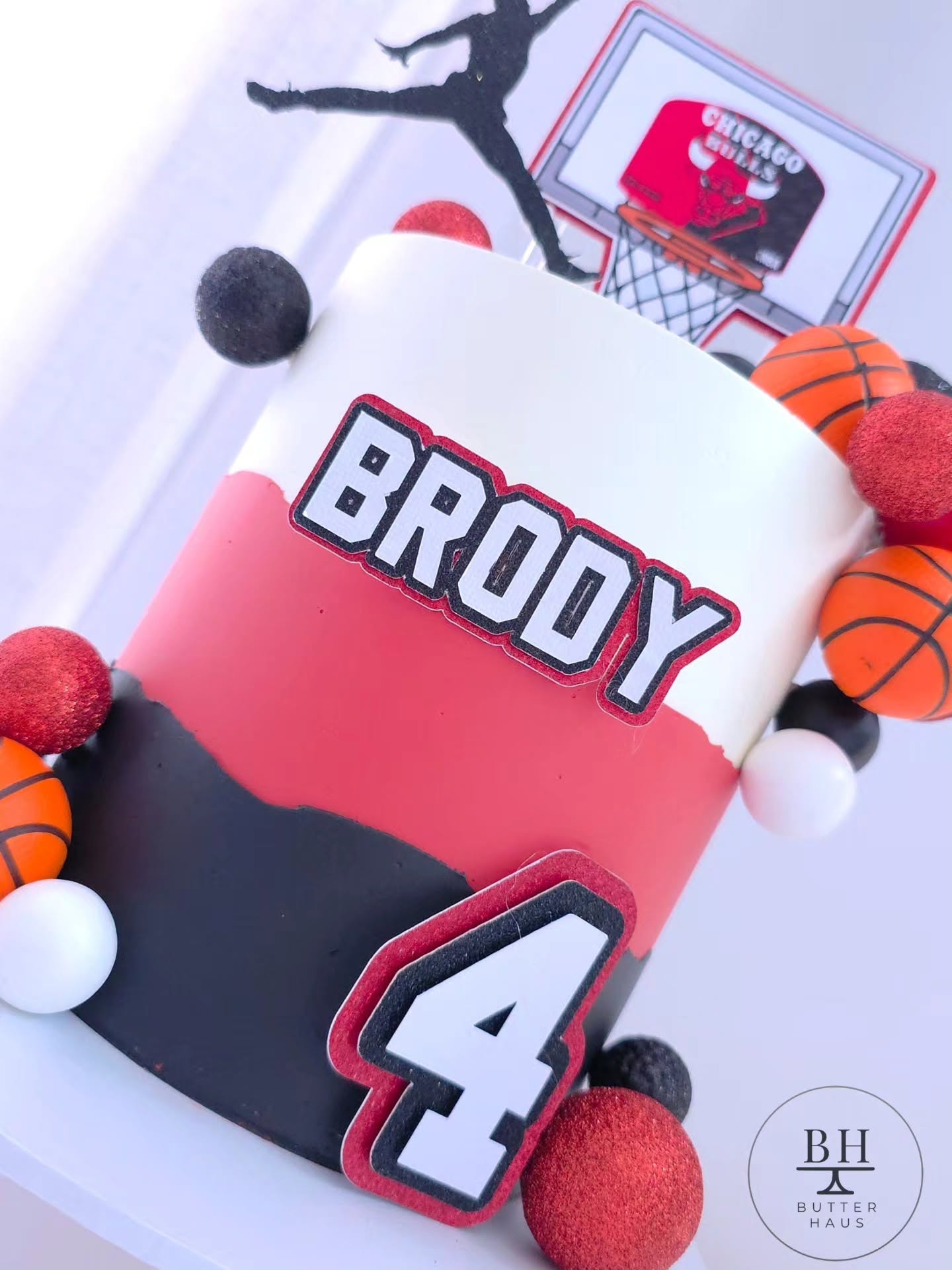 Full front view of the basketball birthday cake with jump-shot silhouette topper, scoreboard-style hoop topper, custom name plaque and number topper