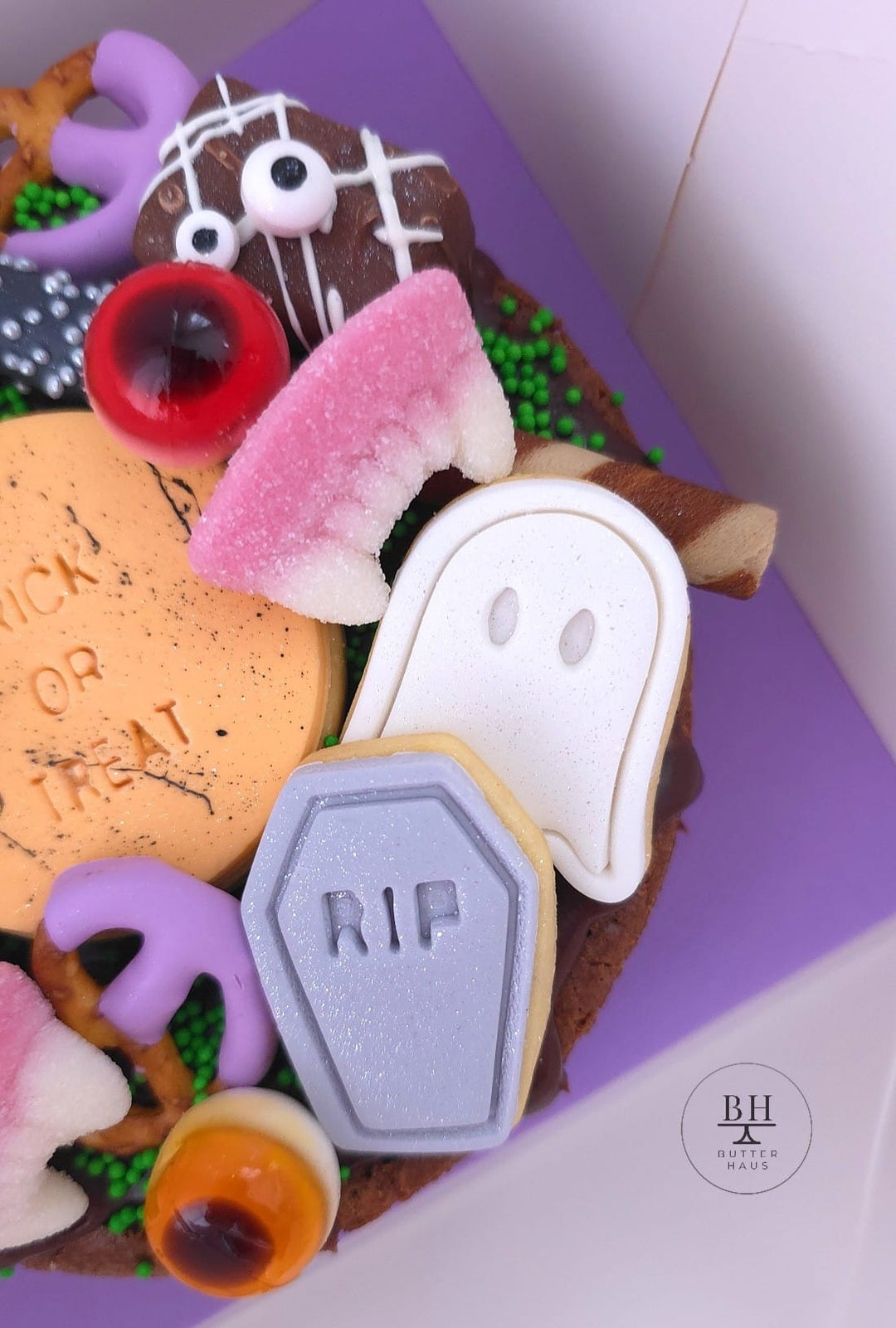 Halloween brownie with RIP tombstone and ghost iced cookies, mummy chocolate bars and purple dipped pretzels