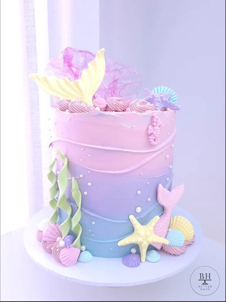 Pink to blue ombre mermaid birthday cake with mermaid tails, wafer paper sails and shells