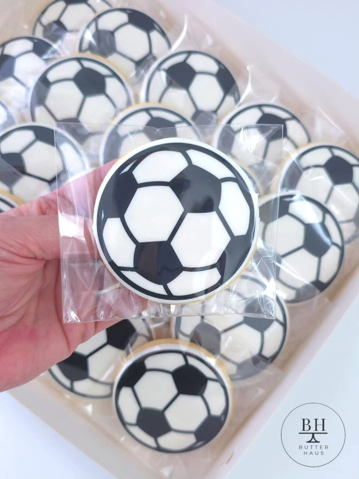 Black and white iced soccer ball cookies in clear heat sealed bags in a box