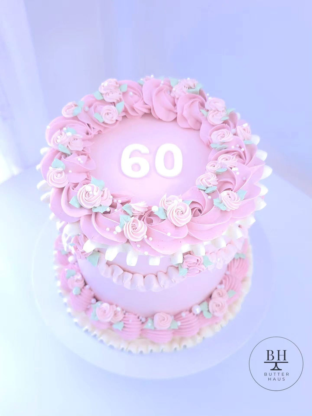 Pink vintage birthday cake with piped roses, mint leaves, ruffles, pearl sprinkles and number topper