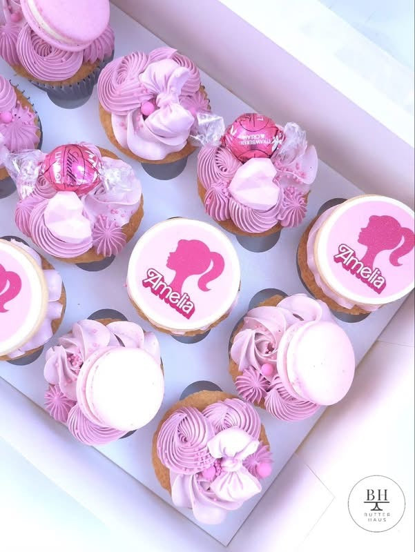 Pink and lilac buttercream cupcakes with macarons, chocolate balls, fondant bows and ponytail name discs