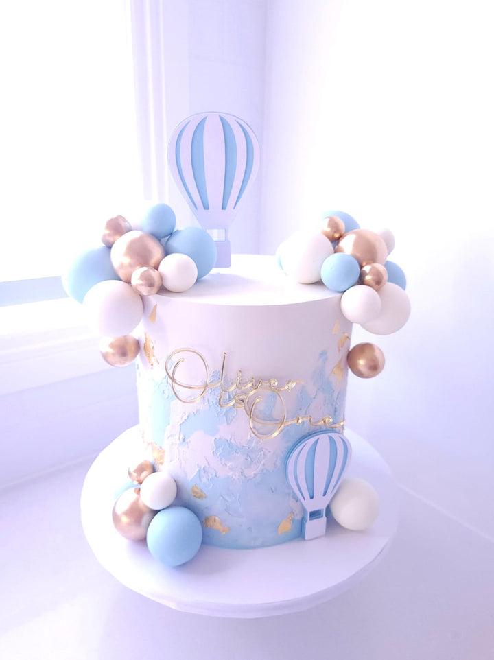 Up, Up &amp; Away birthday cake with textured buttercream, gold leaf and cardstock hot air balloons