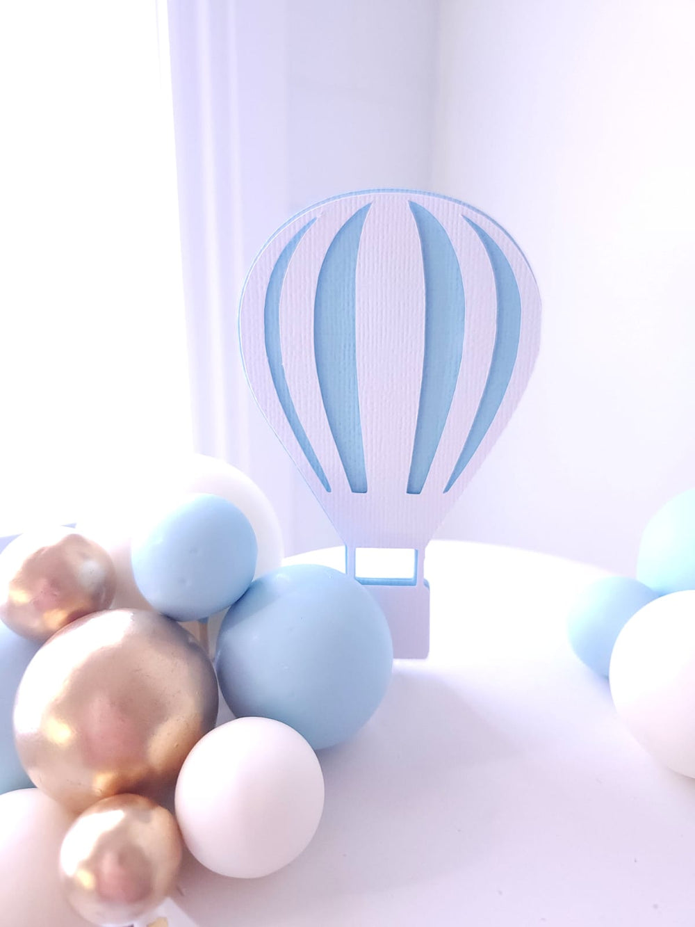 Close-up of balloon baubles and gold leaf detail on Up, Up & Away cake