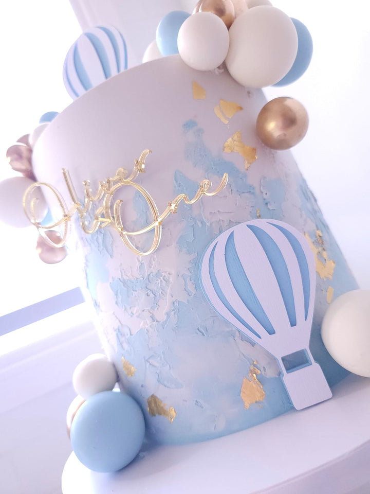 Side view of Up, Up &amp; Away cake showing custom name topper