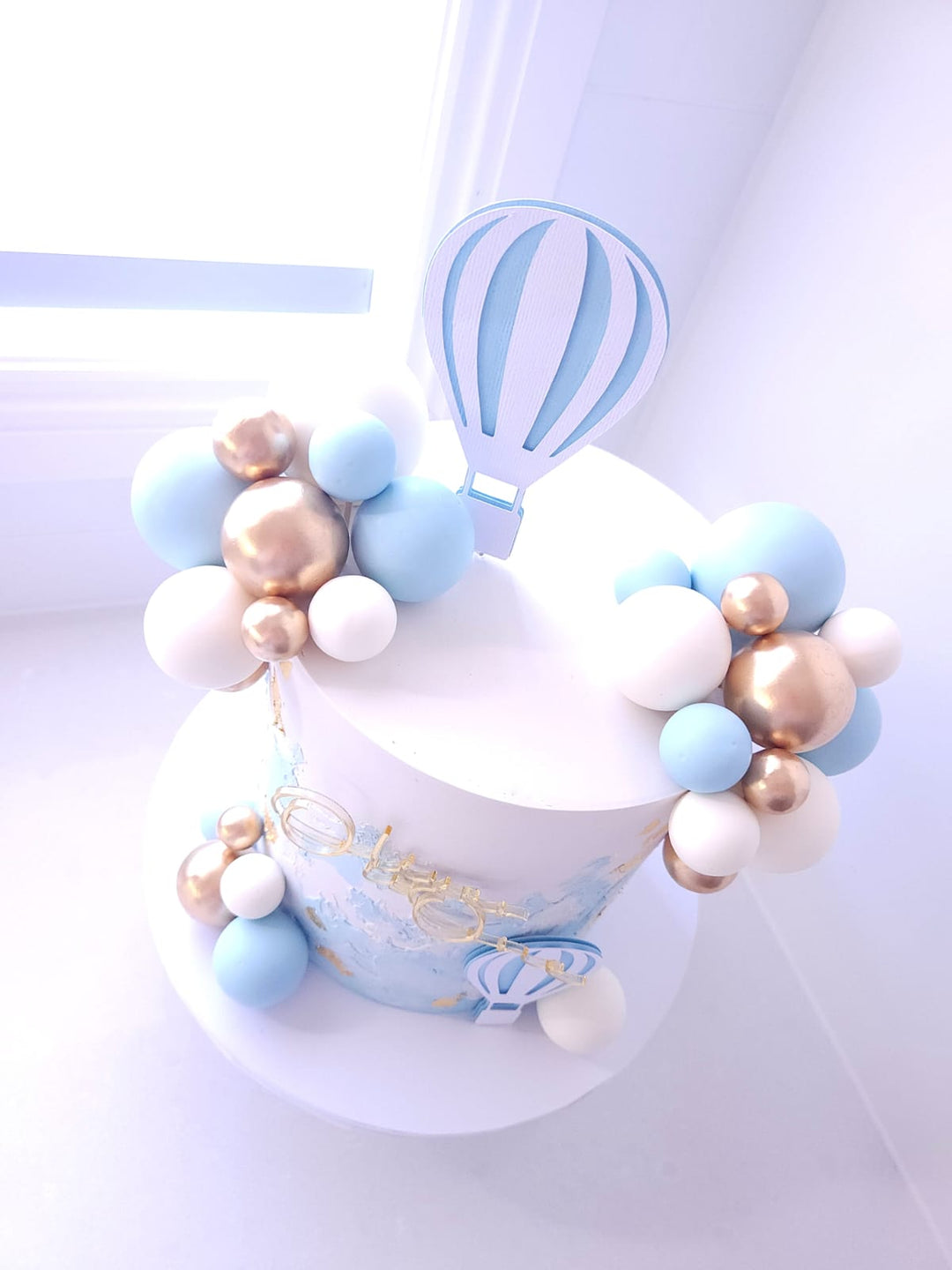 Up, Up &amp; Away cake styled for a first birthday celebration