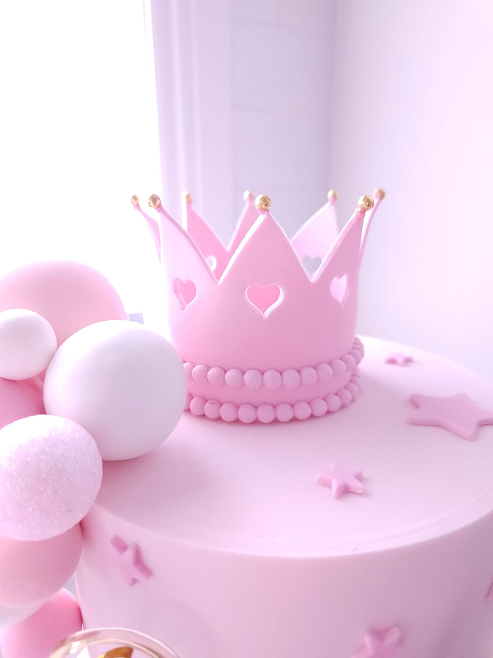 Close-up of handmade fondant crown and bow on Once Upon A Bow cake