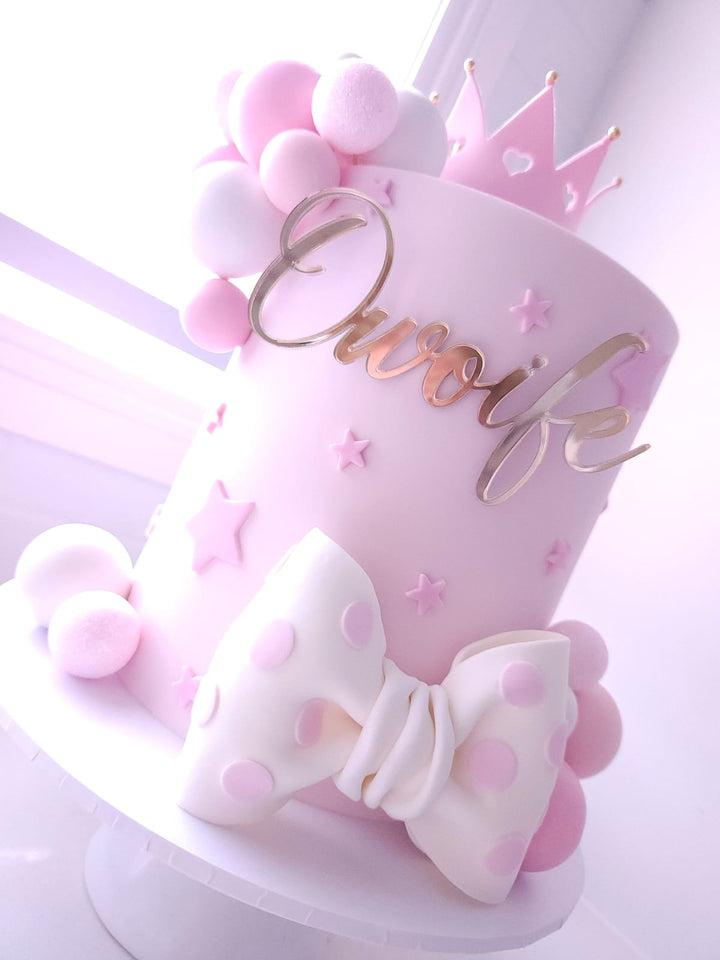 Side view of Once Upon A Bow birthday cake with custom name topper