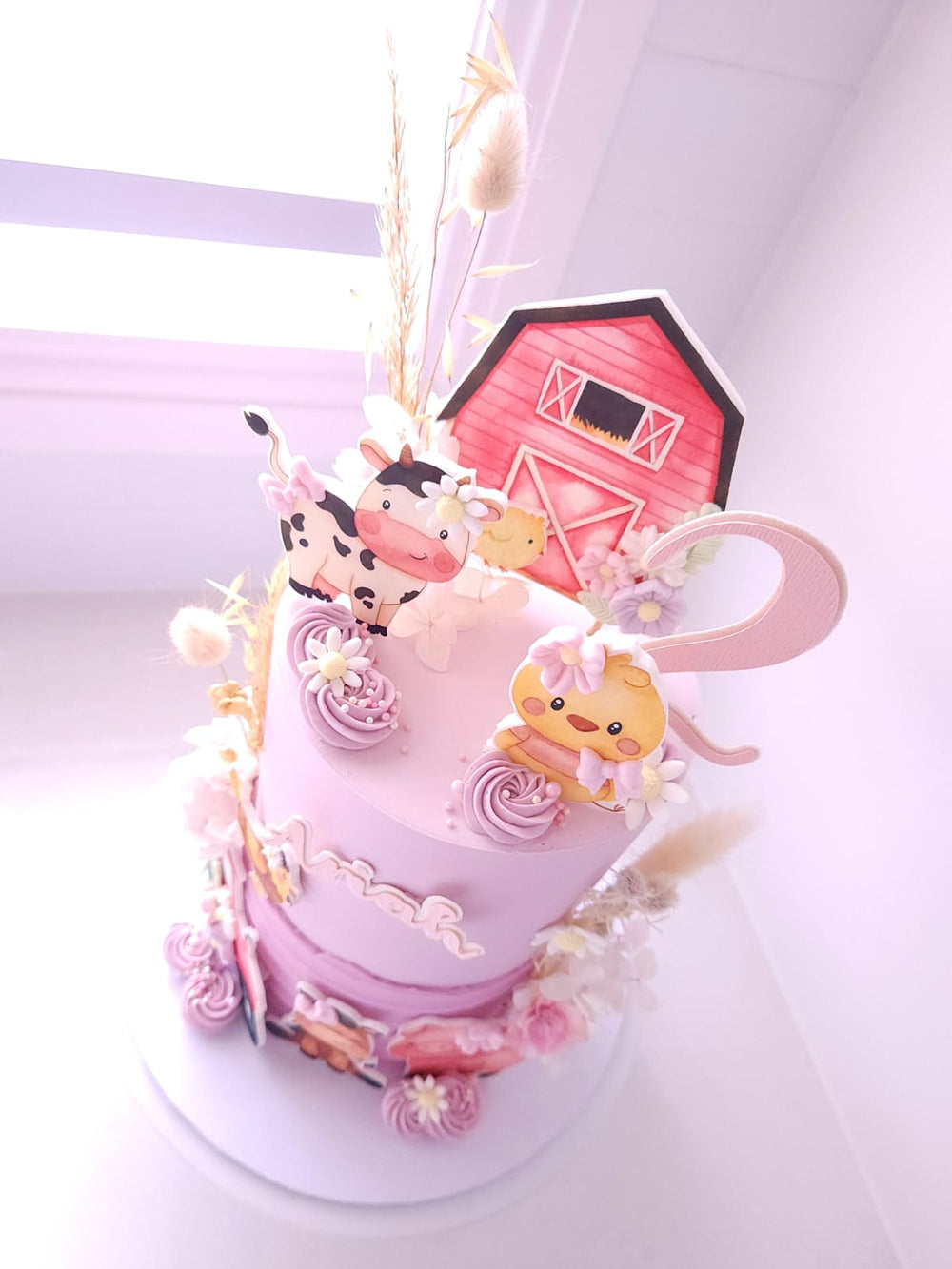 Close-up of dried florals and farm animal details on Little Farm Friends cake