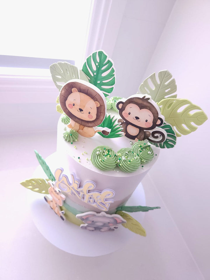 Close-up of fondant leaves and Wild Ones topper on Sweet Safari cake