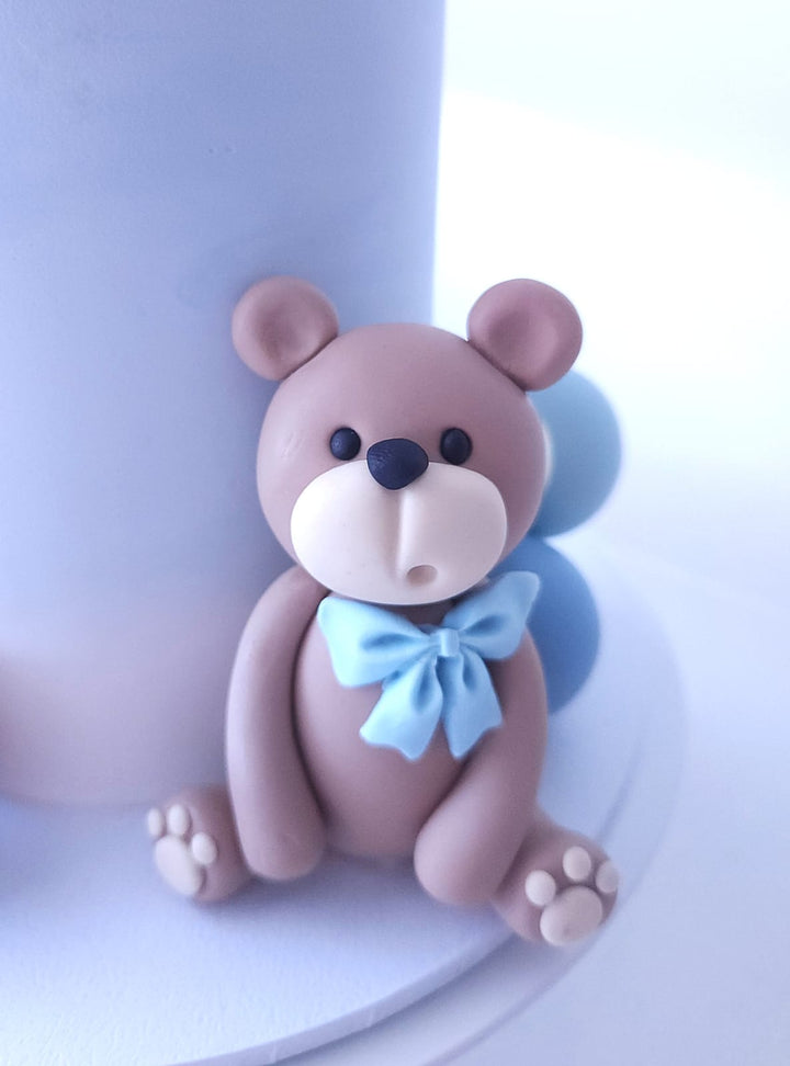 Close-up of fondant teddy bear and bow detail on Hello Baby Bear cake