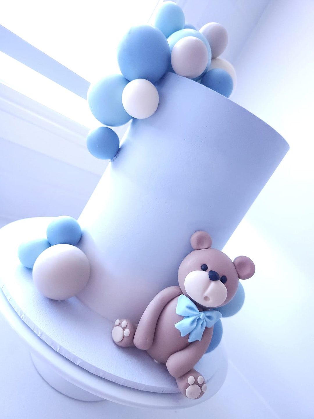 Side view of Hello Baby Bear birthday cake with balloon bauble details