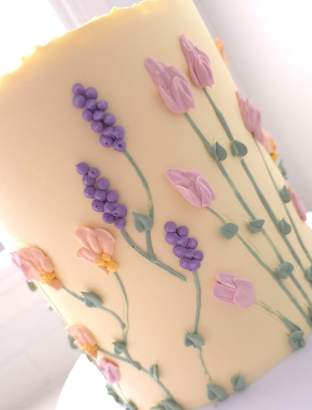 Close-up of hand-piped florals and flowing stems on Floral Bloom cake