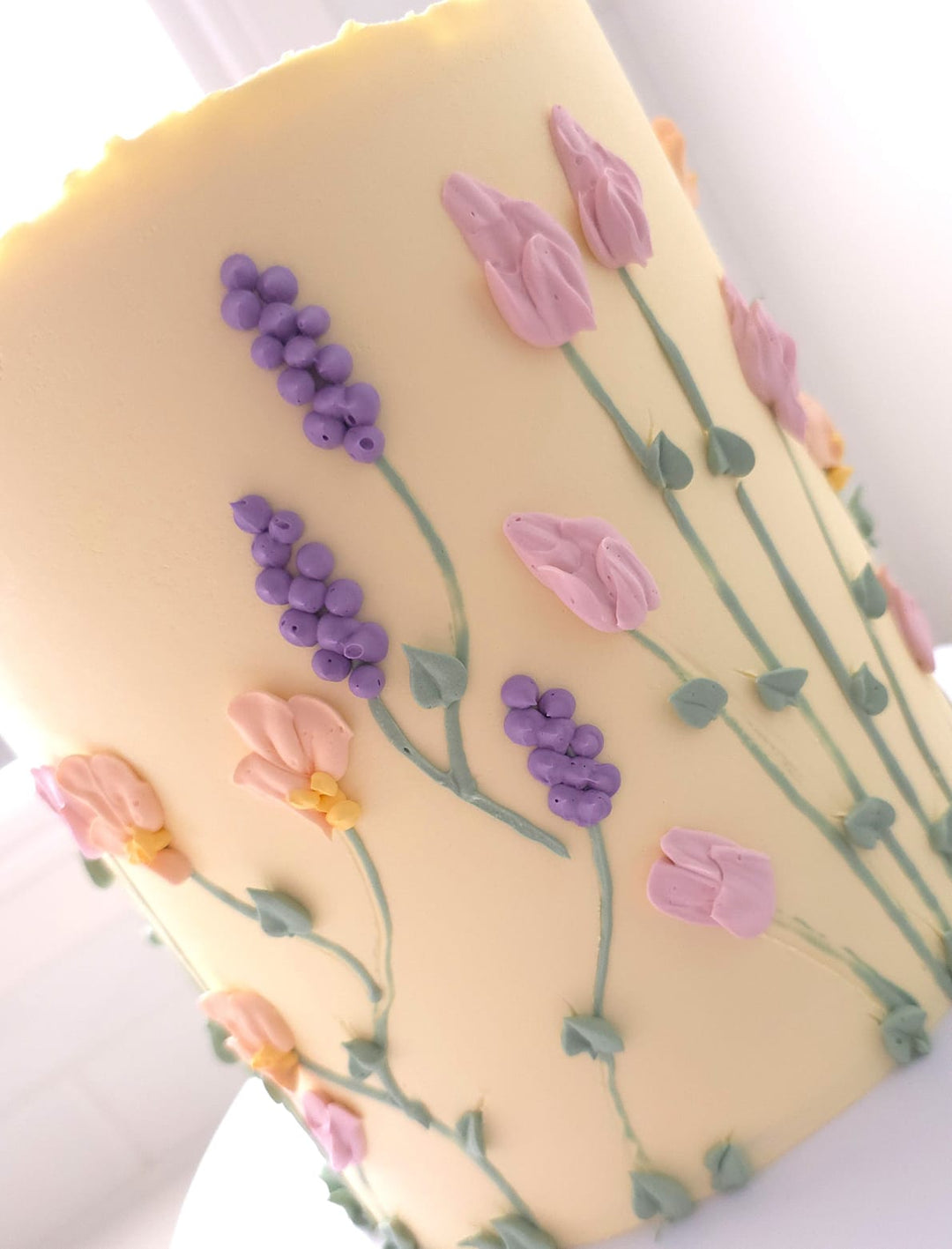 Close-up of hand-piped florals and flowing stems on Floral Bloom cake