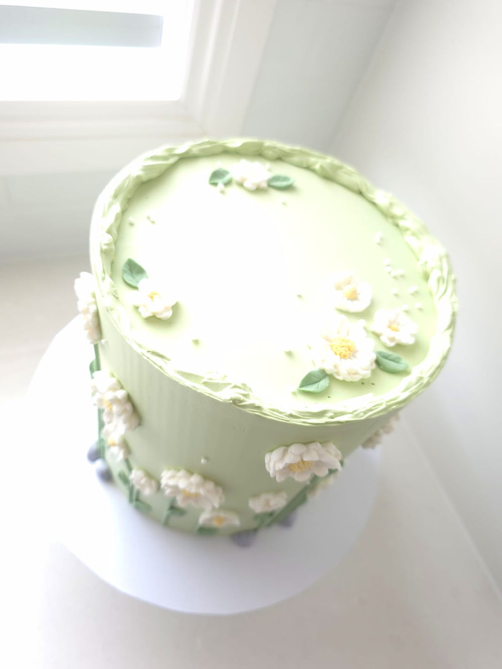 Close-up of hand-piped florals with yellow centres on Sweet Meadow cake
