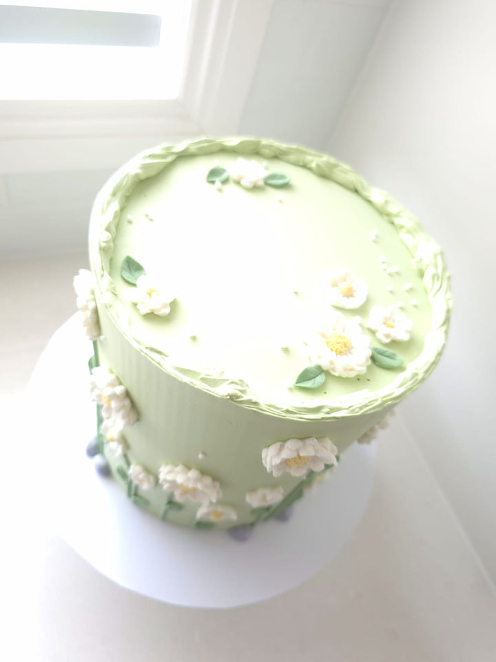 Close-up of hand-piped florals with yellow centres on Sweet Meadow cake