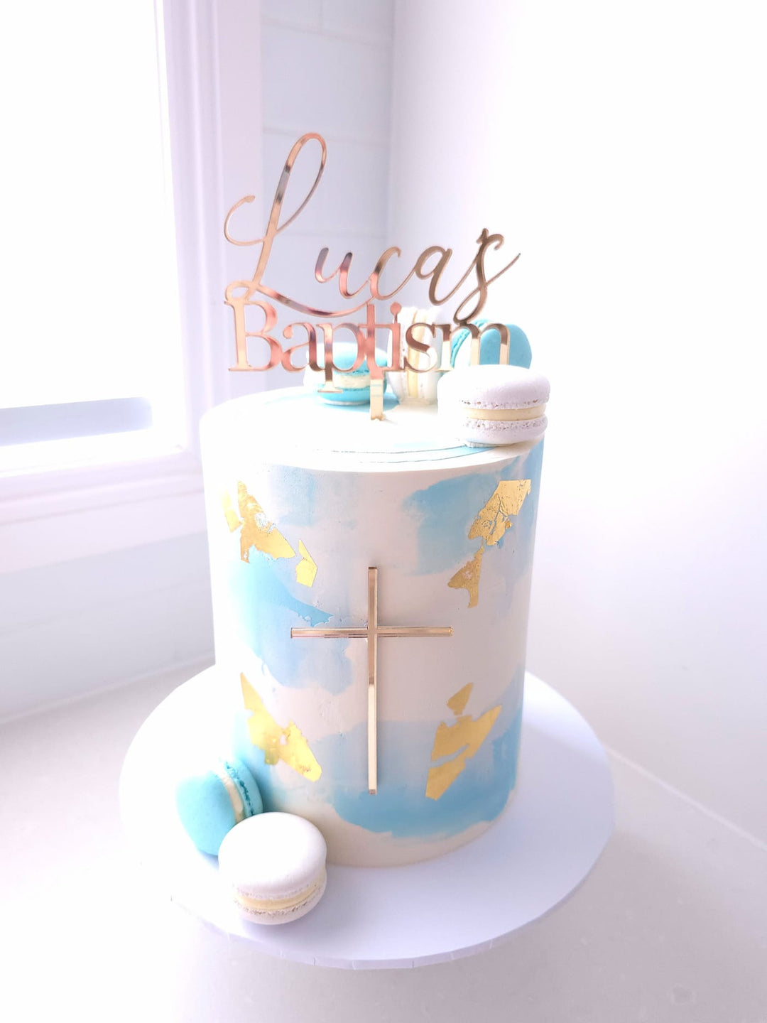 Blessed Beginnings watercolour buttercream christening cake with macarons, leaf detailing and acrylic name and cross topper